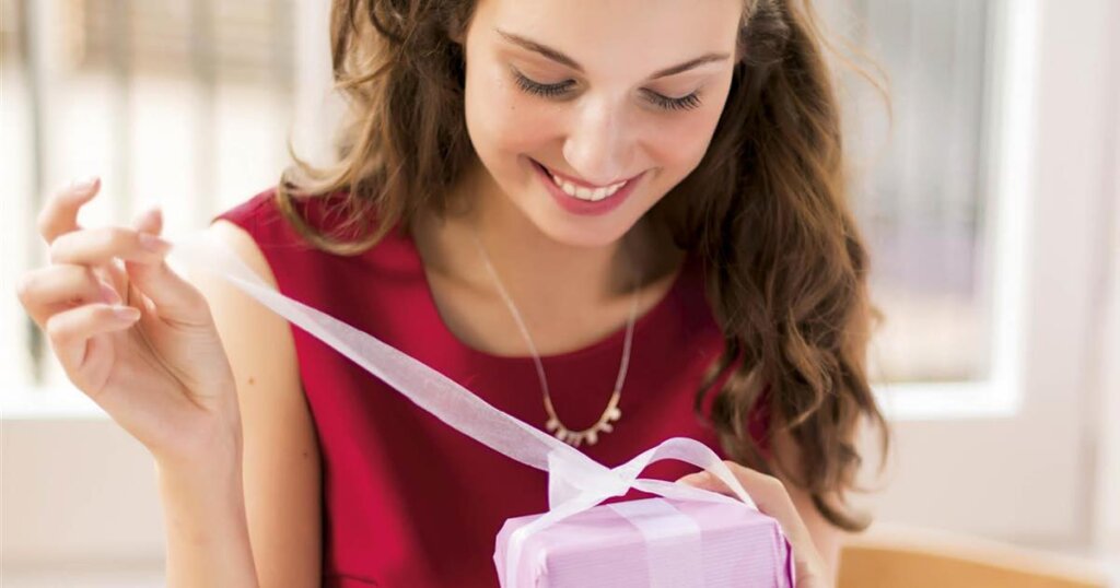 mujer abriendo un regalo en san Valentín
